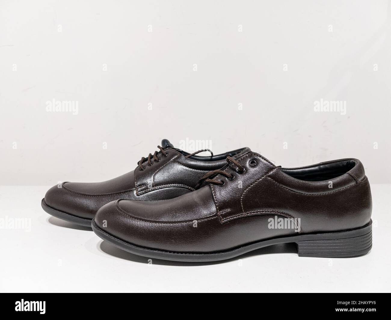 Ein Paar formelle schwarze Schuhe mit Schnürsenkeln auf weißem Hintergrund Stockfoto