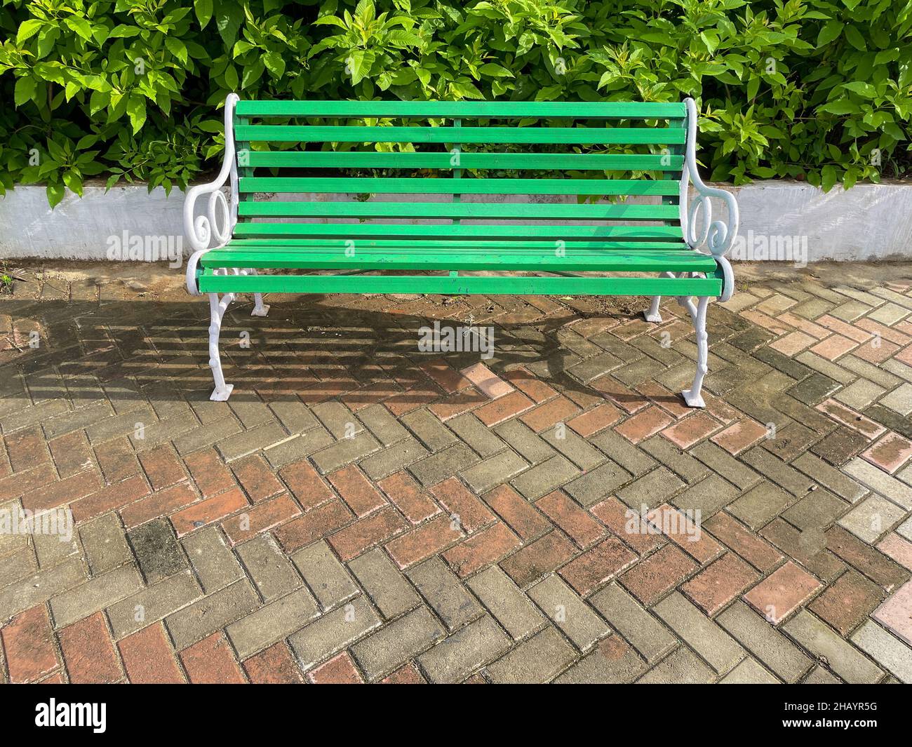 Eine schöne Sitzbank in einem Park mit ruhiger und grüner Umgebung platziert Stockfoto