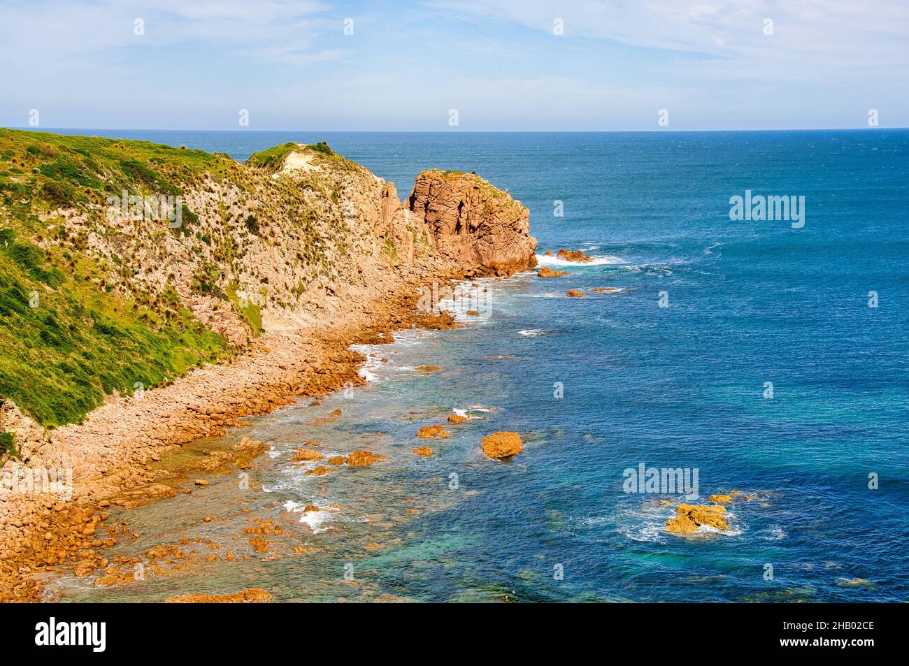 Cowrie Bay ist eine nach Westen ausgerichtete, felsige Bucht mit einem groben Sandstrand, der aus der Brandung besteht, die auf dem umliegenden Granit - Phillip Island, Victoria - abstampft Stockfoto