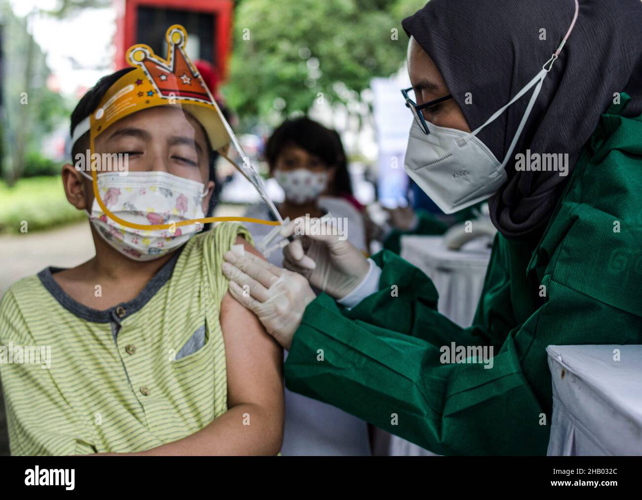 Bandung, Indonesien. 16th Dez 2021. Ein Gesundheitsmitarbeiter gibt einem Jungen während der Impfung gegen COVID-19 gegen Kinder im Alter von 6 bis 11 Jahren eine Dosis des chinesischen Sinovac-Impfstoffs in Bandung, West Java, Indonesien, am 16. Dezember 2021. Quelle: Septianjar/Xinhua/Alamy Live News Stockfoto