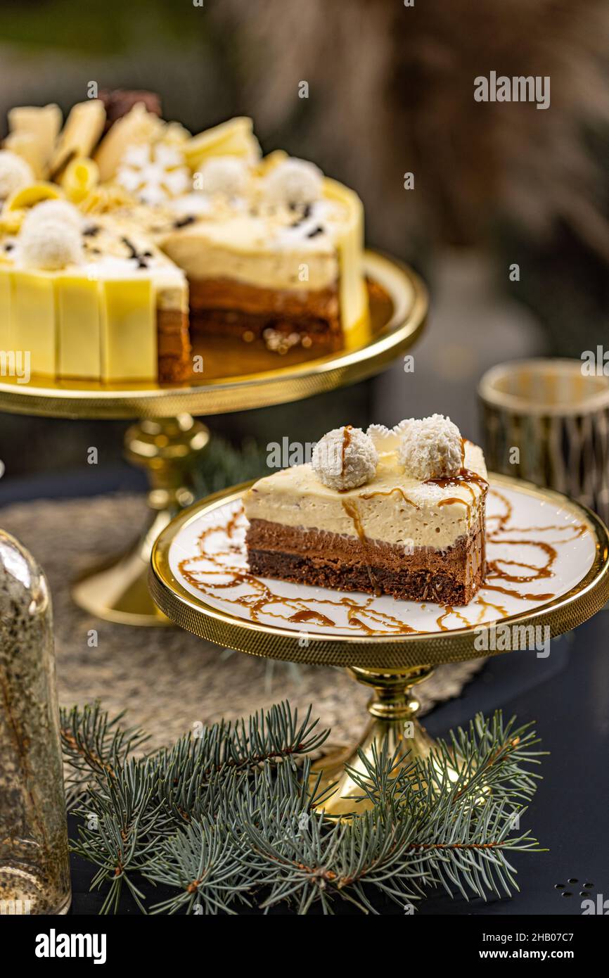 Ein Stück köstlicher, dreilagiger Schokoladenmousse-Torte, verziert mit Kokosnusskugel Stockfoto