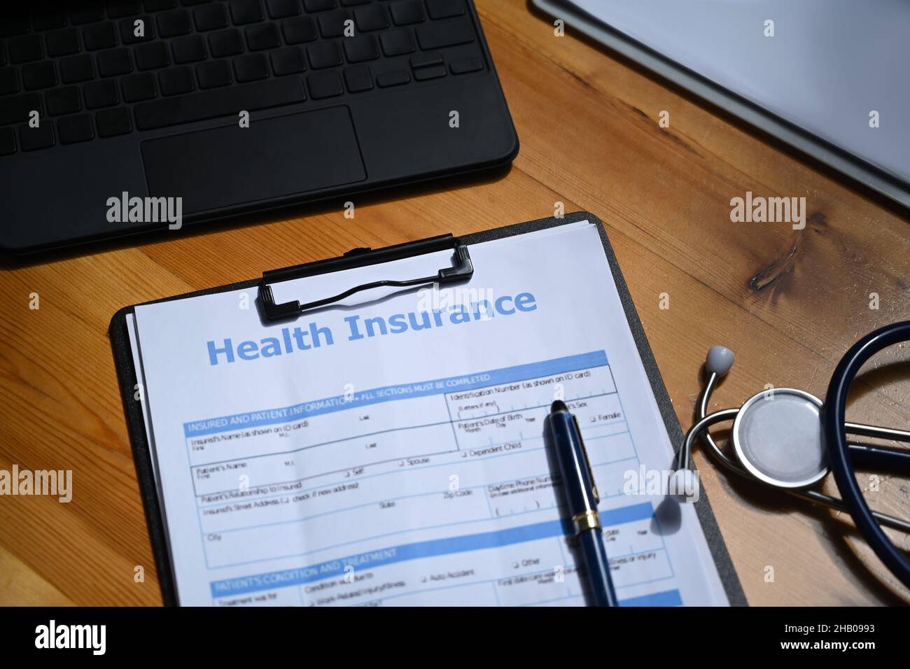 Krankenversicherungsformular und Stethoskop auf Holztisch. Konzept der Krankenversicherung. Stockfoto