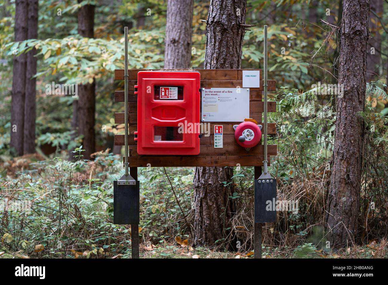 Waldbrandbekämpfungsstation mit Feuerlöscher, Warnzeichen und Symbolen im Wald. Rettungszentrum mit Alarmglocke zur Alarmierung der Feuerwehrleute Stockfoto