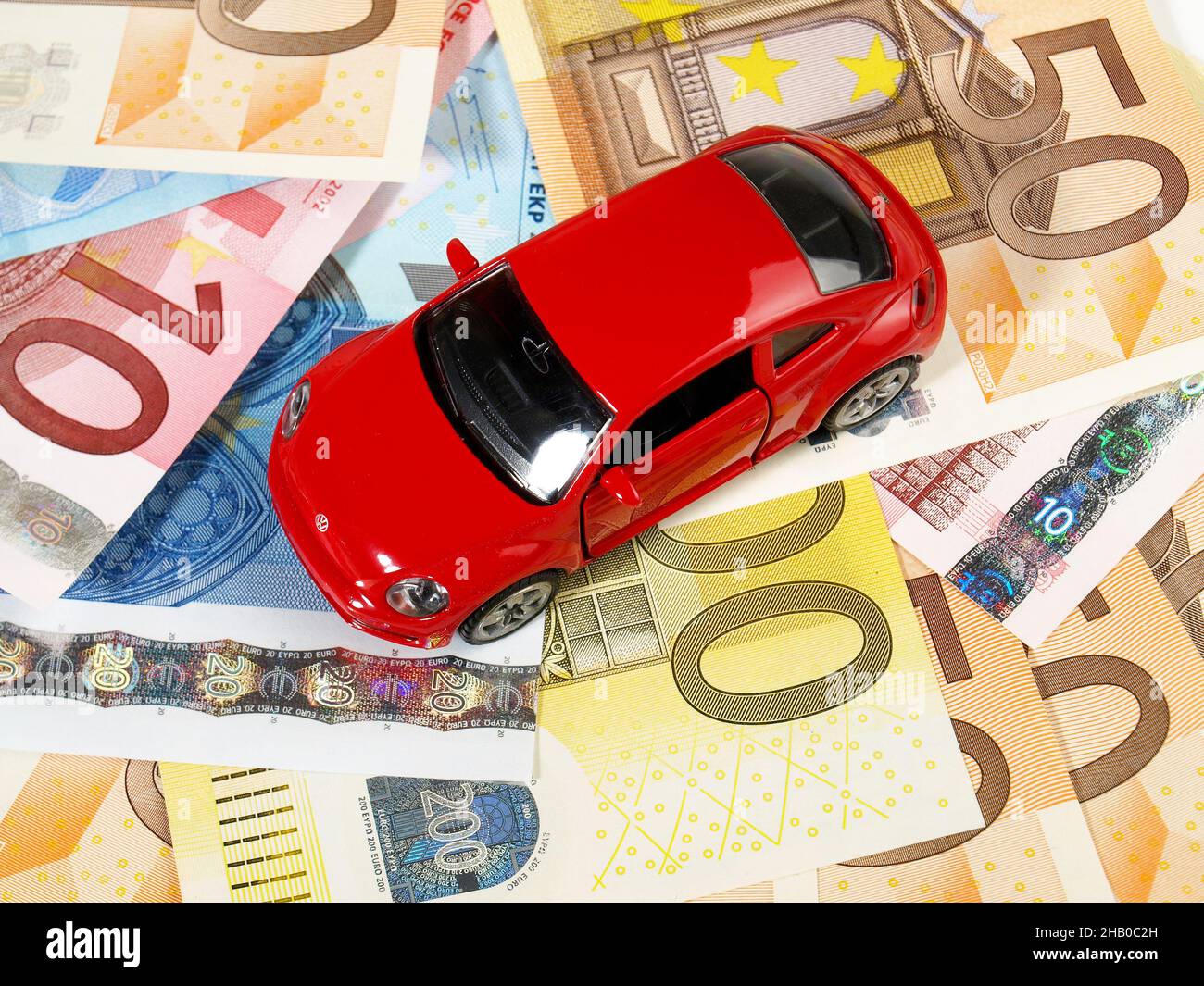 Rotes VW Käfer Spielzeugauto auf EURO-Banknoten Stockfoto