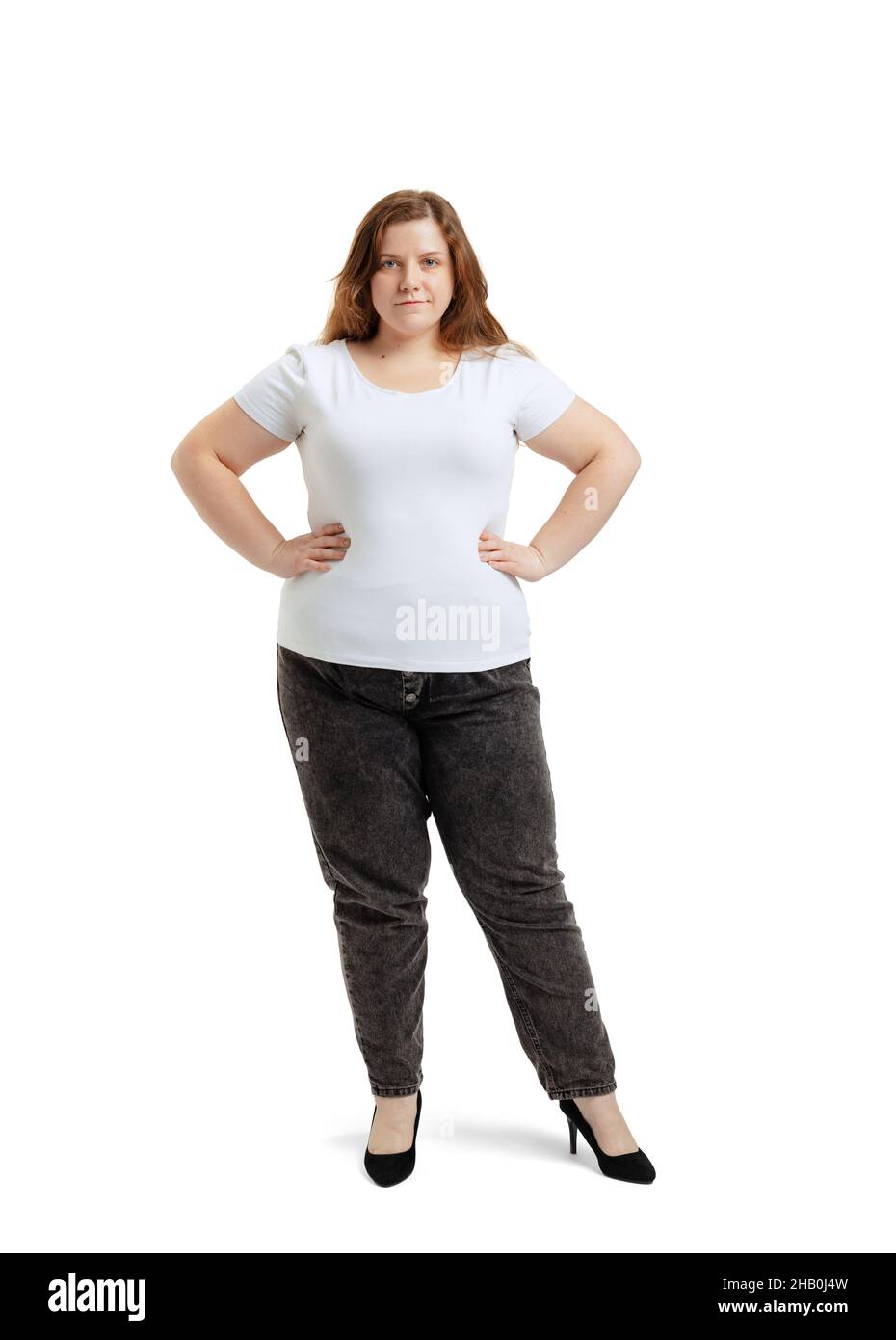 Ganzkörperportrait einer Frau in Übergröße, die weißes T-Shirt und Jeans trägt und isoliert auf weißem Studiohintergrund posiert. Body-positive-Konzept Stockfoto