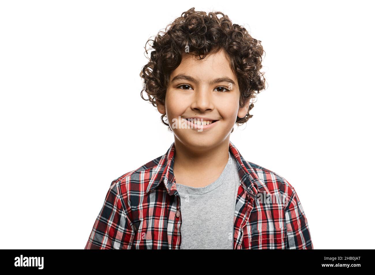 Porträt eines hübschen Jungen aus dem Nahen Osten mit einem toothy Lächeln im karierten Hemd, isoliert auf weißem Hintergrund Stockfoto