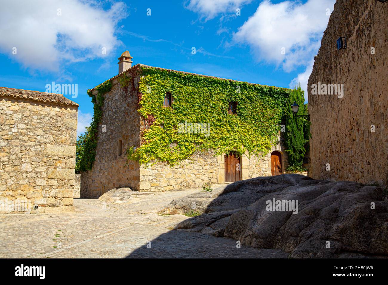 Beige Stein Bauernhaus Fassade mit schreinerer Abdeckung der Spitze Stockfoto