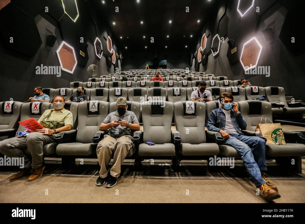 Pasay City, Philippinen. 16th Dez 2021. In einem Kino, das in einem Einkaufszentrum in Pasay City, Philippinen, am 16. Dezember 2021 in einen Impfbereich verwandelt wurde, warten die Menschen darauf, mit COVID-19-Impfstoff geimpft zu werden. Die Philippinen haben die ersten beiden bestätigten Fälle der Omicron-Variante bei zwei Reisenden aus Nigeria bzw. Japan registriert, teilte das Gesundheitsministerium (DOH) am Mittwoch mit. Quelle: Rouelle Umali/Xinhua/Alamy Live News Stockfoto