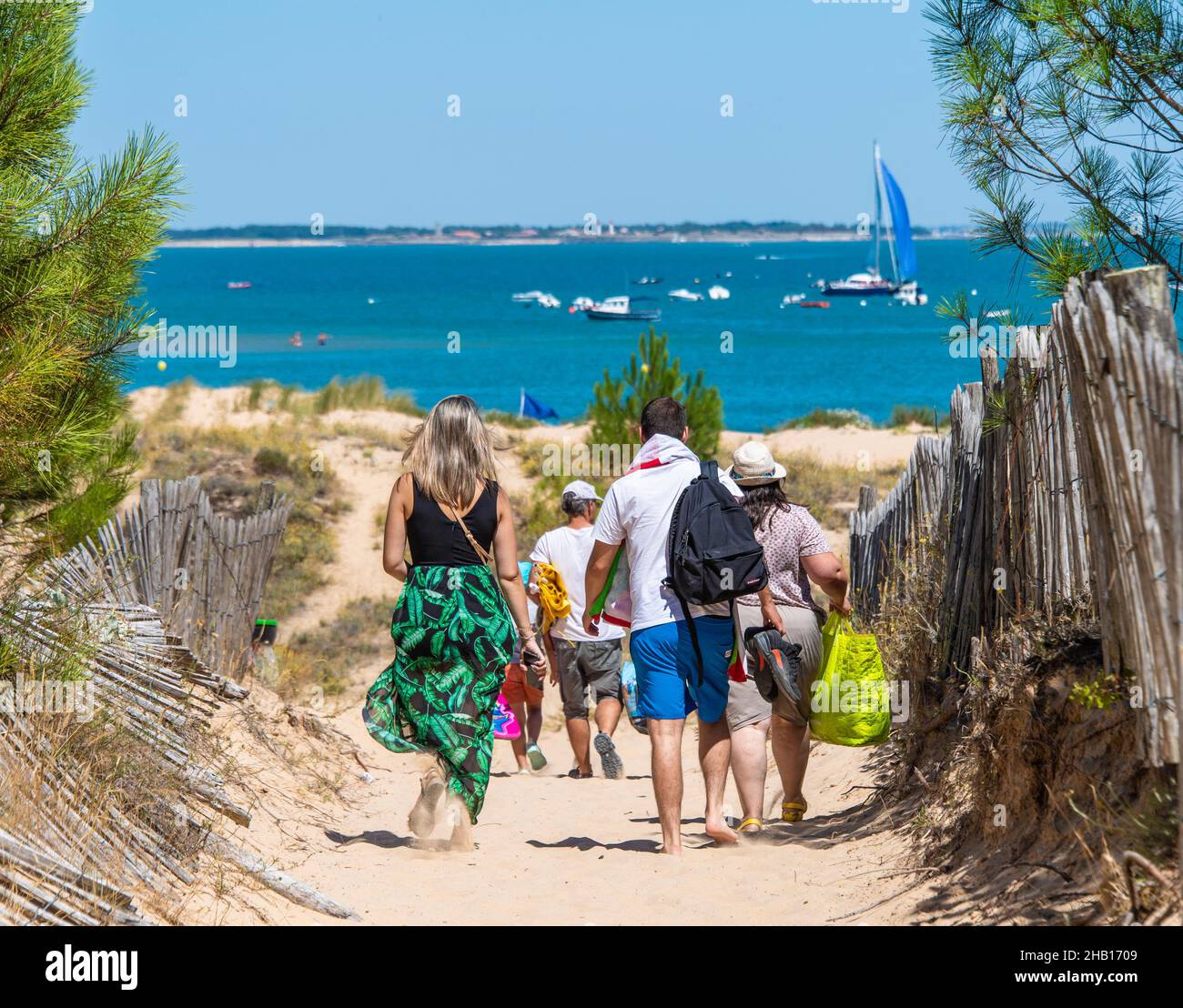 Touristen, die zu einem Strand auf der Insel „Ile d’Oleron“ laufen Stockfoto