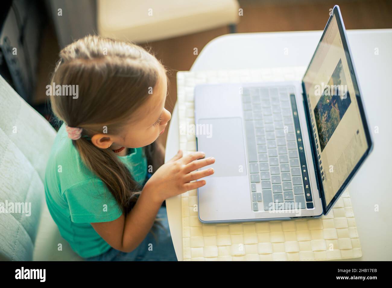 Kleines nettes Mädchen verwendet Laptop, um Videoanruf zu haben Stockfoto