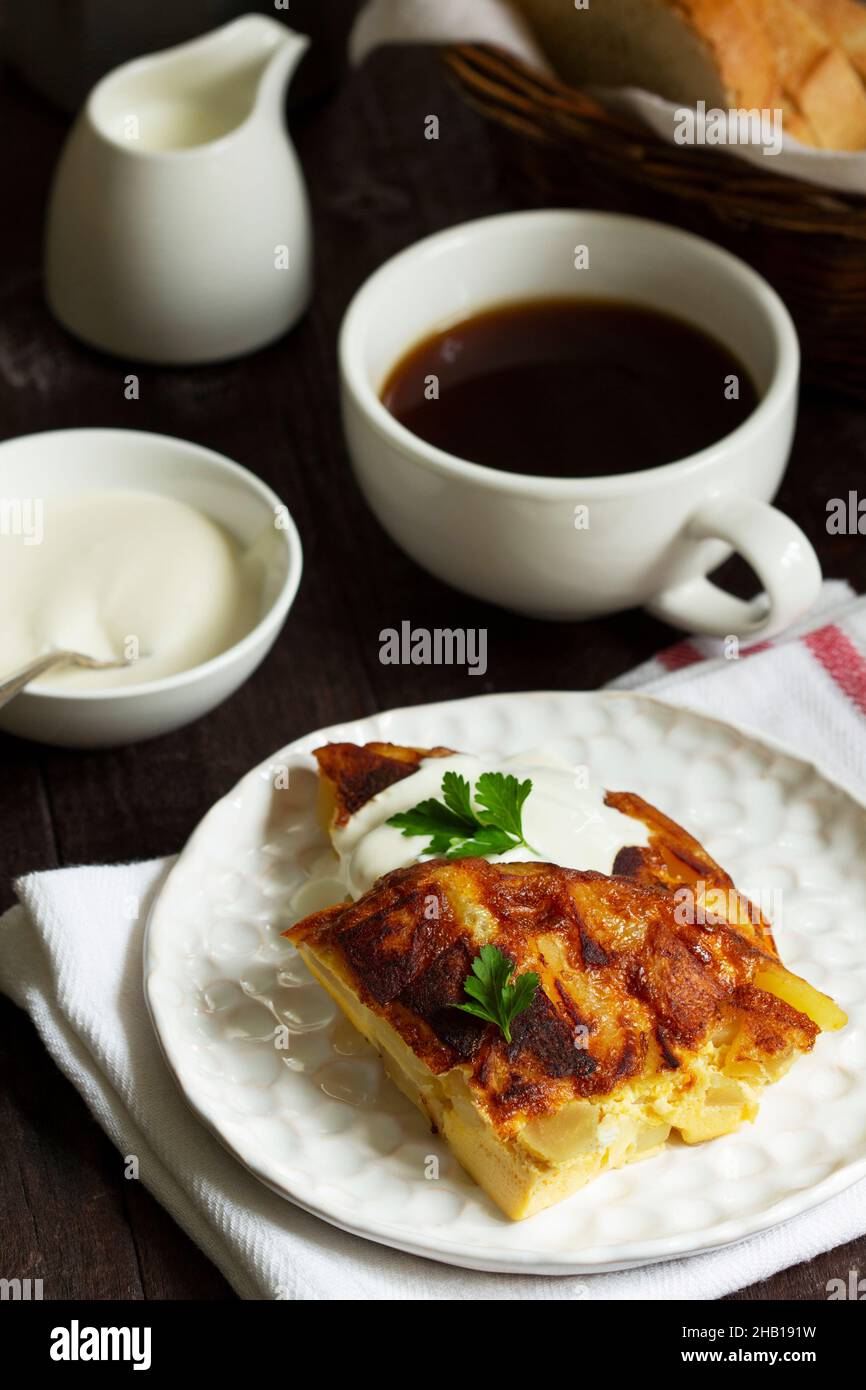 Traditionelles spanisches oder italienisches Omelett mit Kartoffeln, serviert mit Kaffee. Rustikaler Stil. Stockfoto