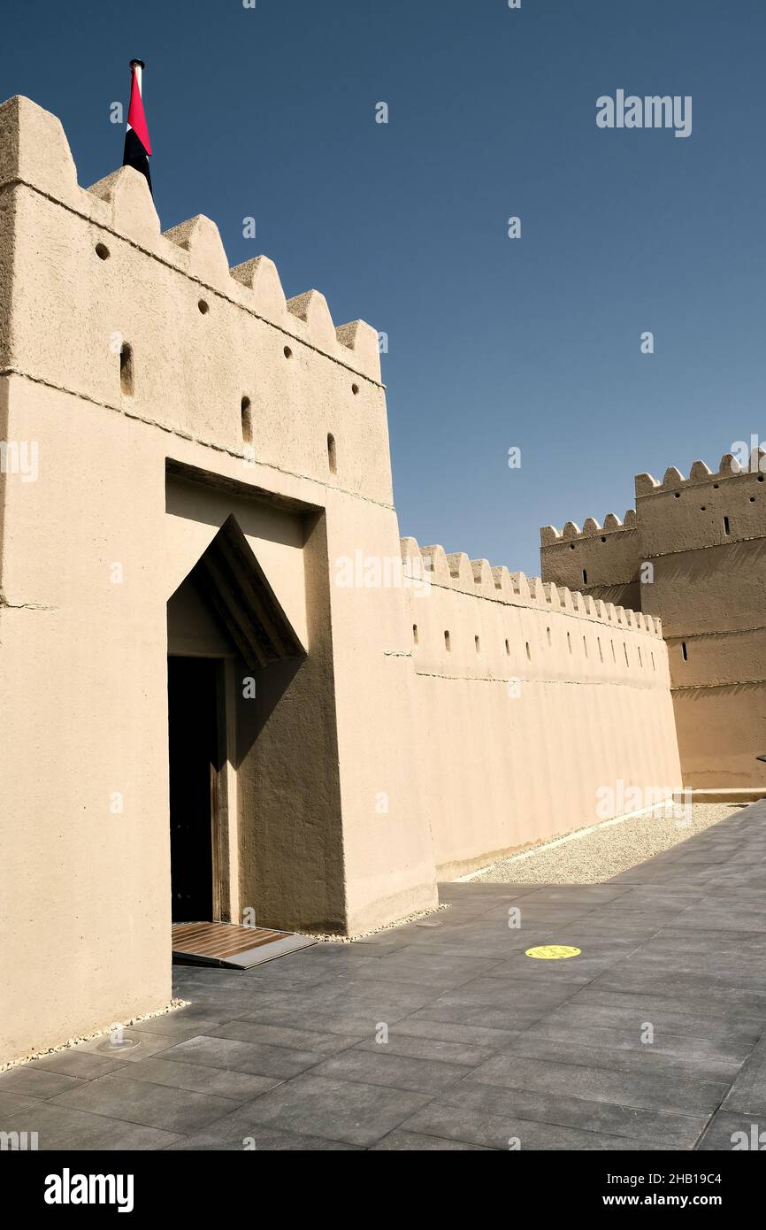 Vertikale Aufnahme der Eingangstür zum berühmten Fort Qasr Al Muwaiji in den Vereinigten Arabischen Emiraten an einem sonnigen Tag Stockfoto