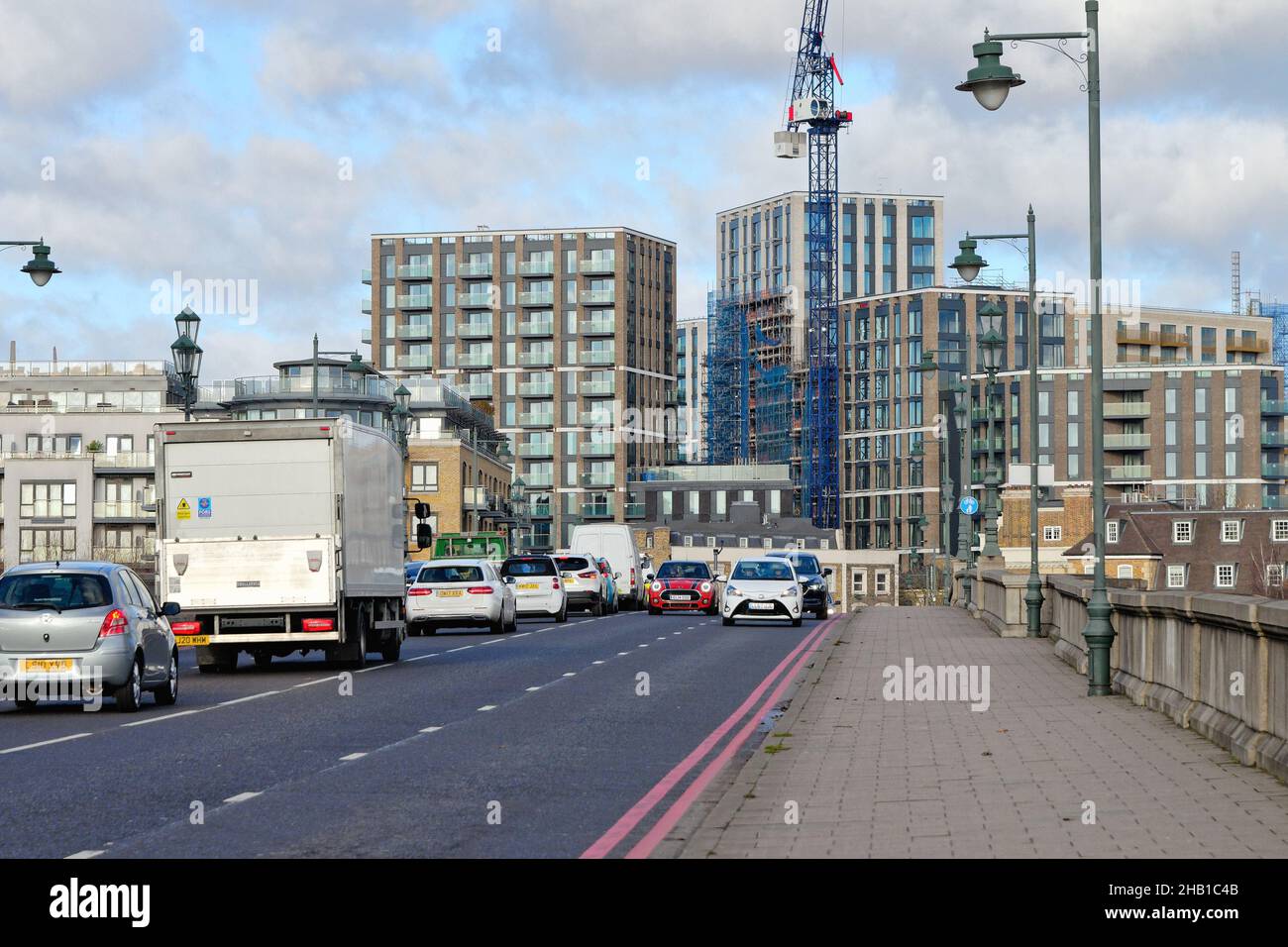 Verkehr Schlange auf Kew Bridge mit modernen Wohngebäuden gebaut und im Bau West London England Großbritannien Stockfoto