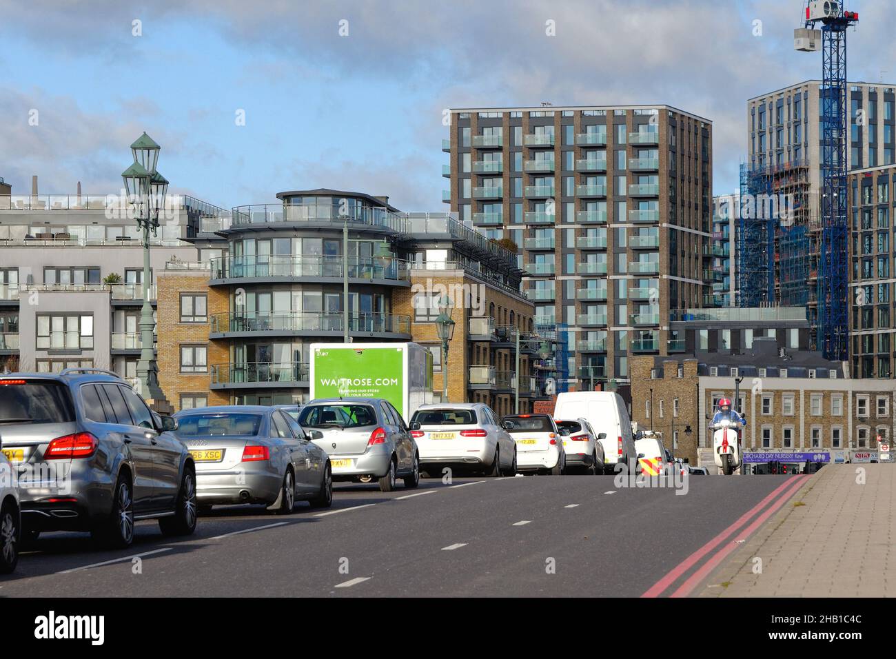 Verkehr Schlange auf Kew Bridge mit modernen Wohngebäuden gebaut und im Bau West London England Großbritannien Stockfoto