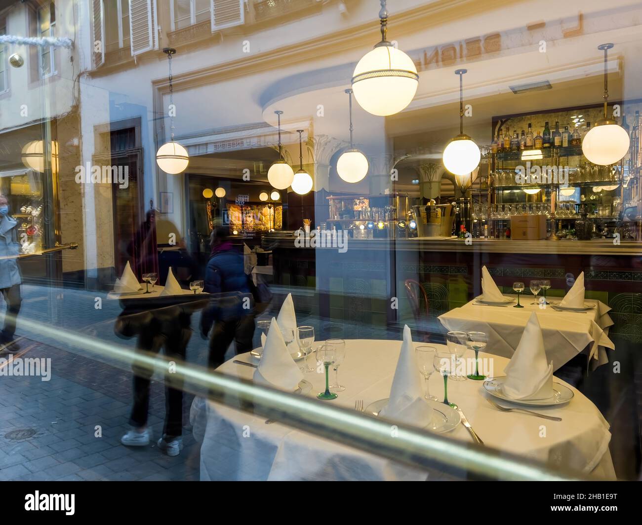 Spaziergang vor dem Flo Restaurant mit Blick auf das Innere durch das Glasfenster Stockfoto