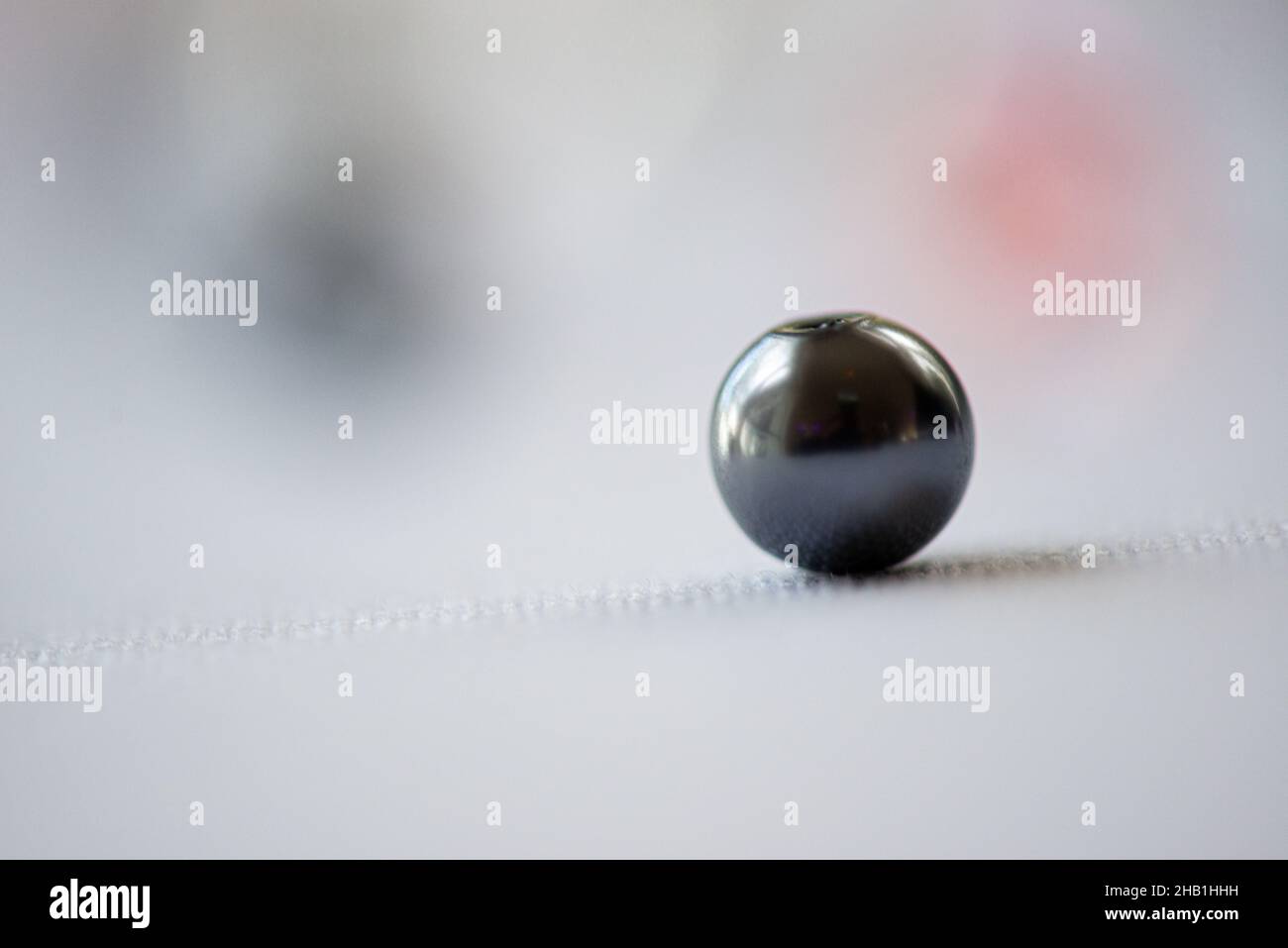 Ein isolierter schwarzer Marmor auf weißem Bokeh-Hintergrund Stockfoto