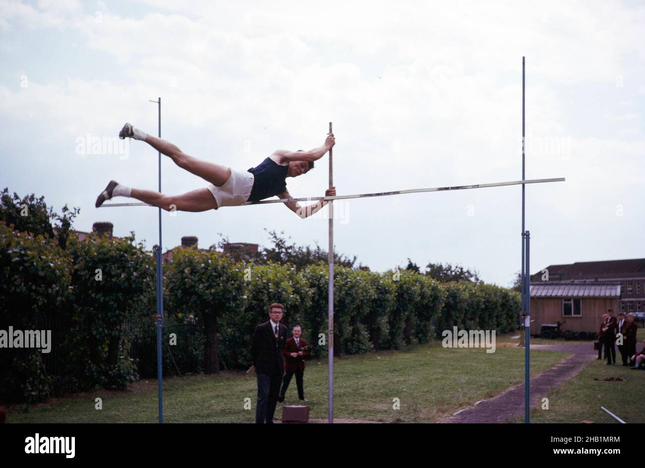 Junge, die 1965 am Sporttag der Sekundarstufe in der Ilford County High School, Essex, England, in einem Polsprung-Event gegeneinander antreten Stockfoto