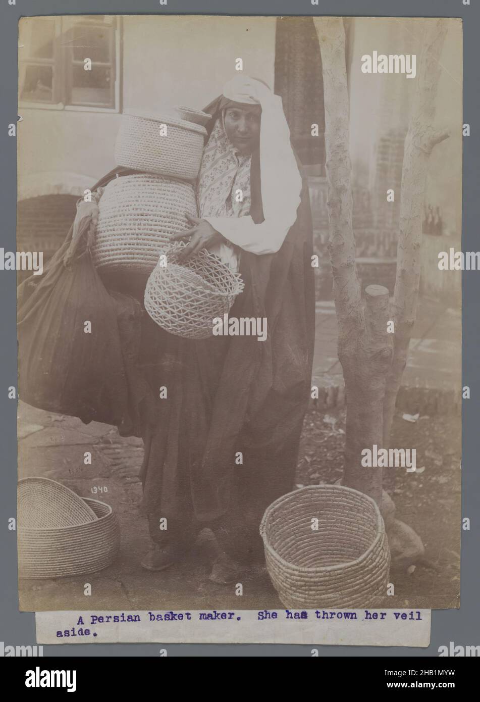 Frau, die Körbe trägt und den Schleier beiseite geworfen hat, eine von 274 Vintage-Fotografien, Silberalbumin-Fotografie, Ende 19th-Anfang 20th. Jahrhundert, Qajar, Qajar-Zeit, 8 3/16 x 6 3/16 Zoll, 20,8 x 15,7 cm, iranisch, Nahost, Persisch Stockfoto
