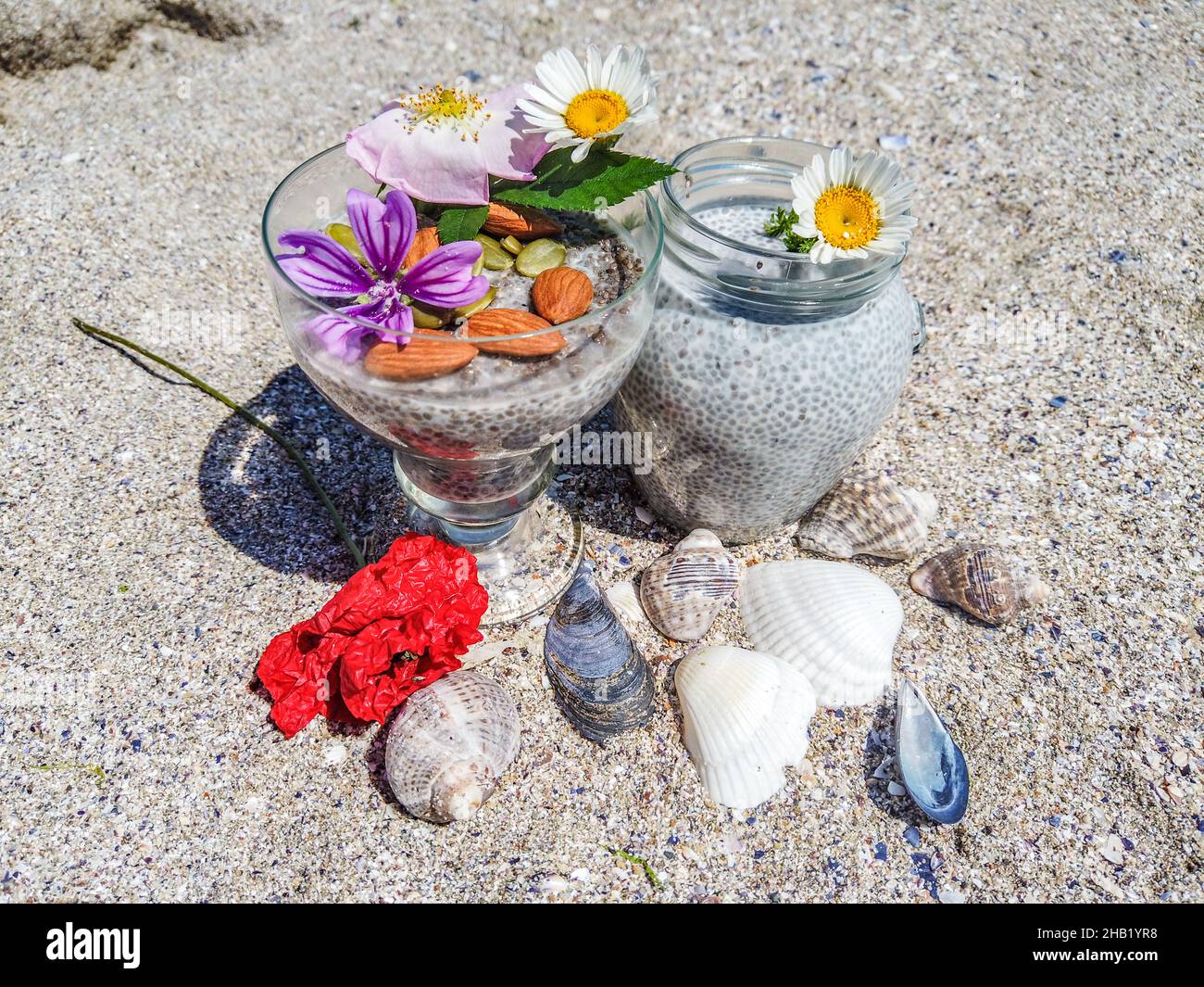 Nahaufnahme eines Chiasamen-Puddings mit Mandelmilch auf dem Hintergrund des Strandes Stockfoto