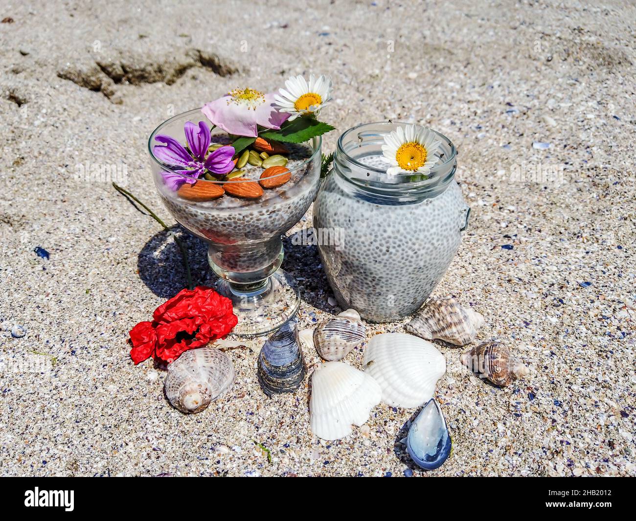 Nahaufnahme eines Chiasamen-Puddings mit Mandelmilch auf dem Hintergrund des Strandes Stockfoto