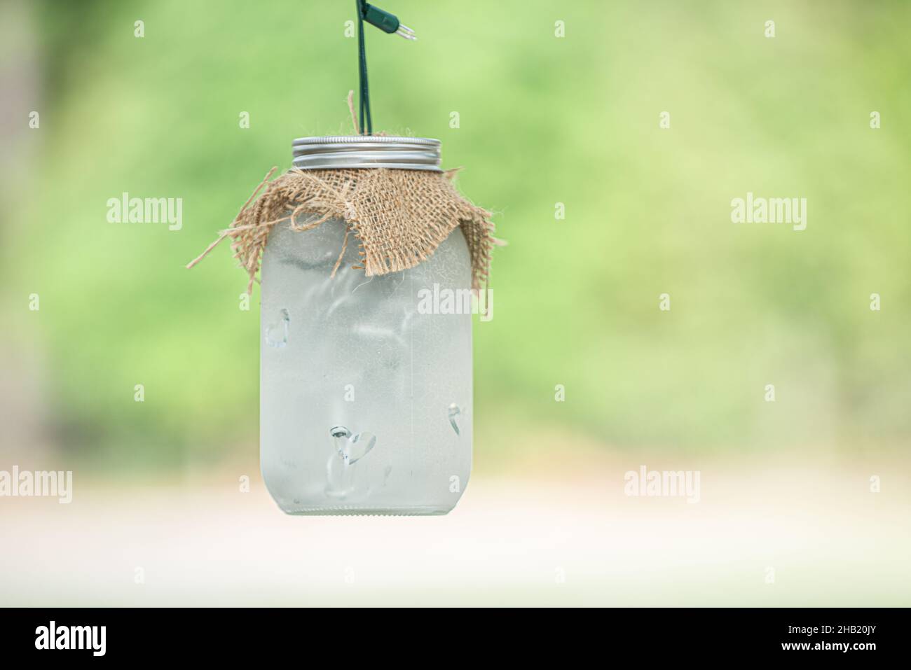 Gefrostete Einmachglas hängend von Baum mit Sackleinen Abdeckung Dekoration Stockfoto