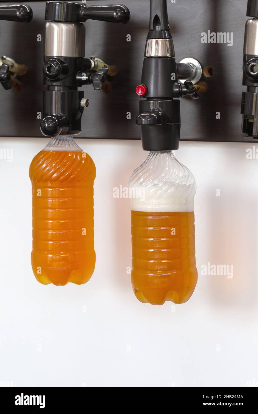 Neue moderne Bierzapfanlagen mit Plastikflaschen an der Theke im Pub Stockfoto