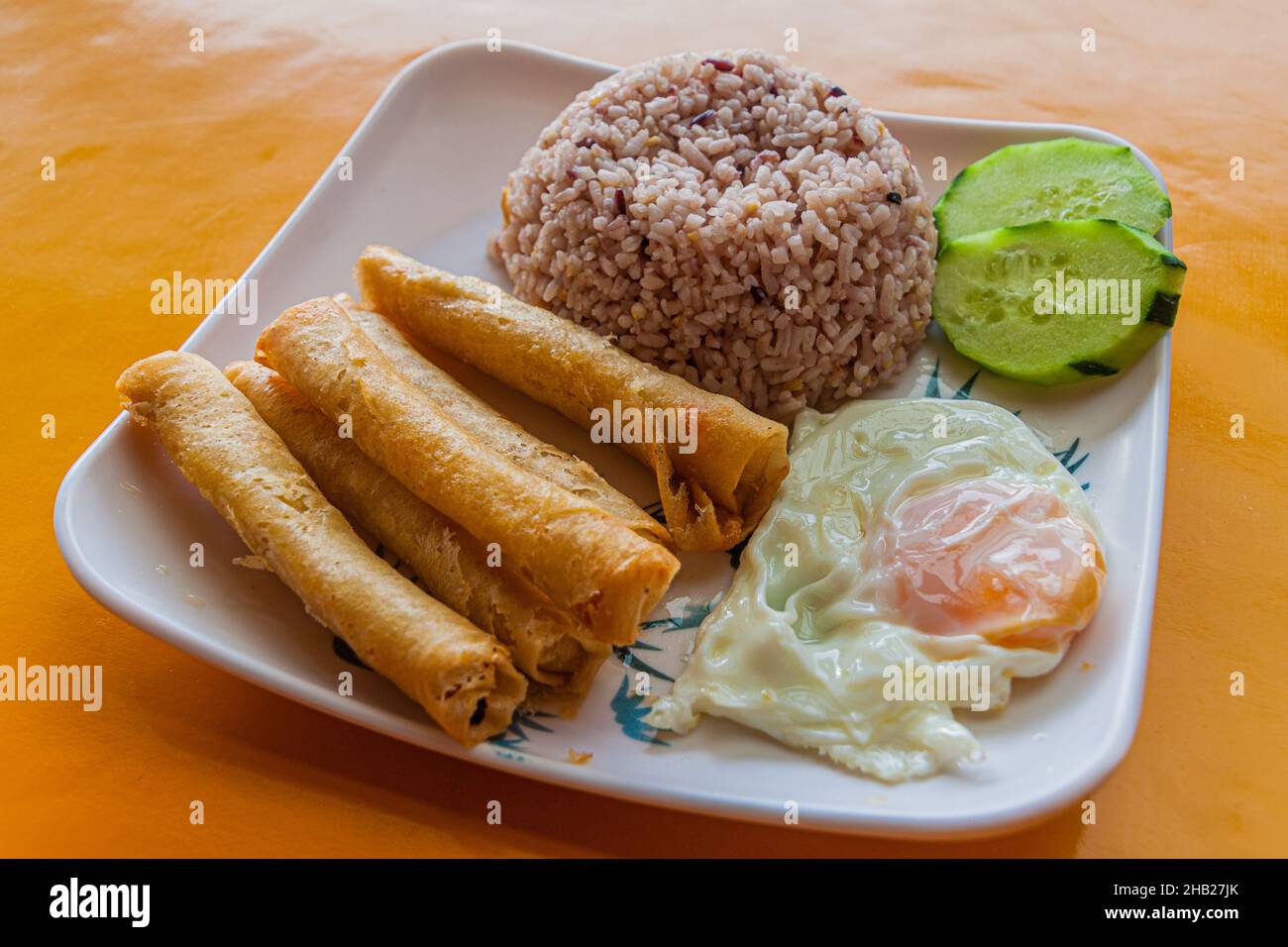 Frühstück auf den Philippinen - Reis mit gebratenen Brötchen (Lumpia) und Ei Stockfoto
