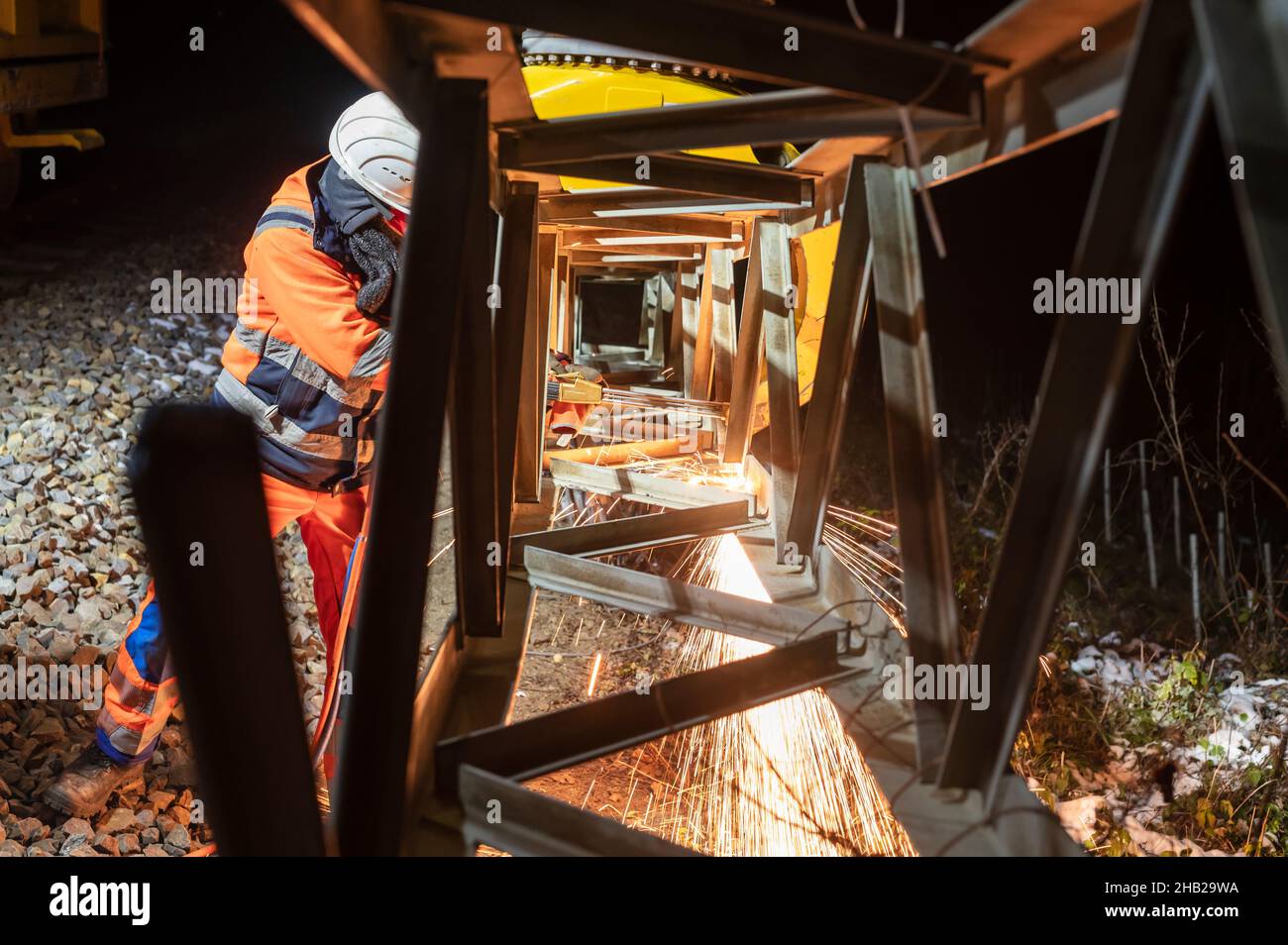 Ein Arbeiter schneidet einen Gittermast Stockfoto