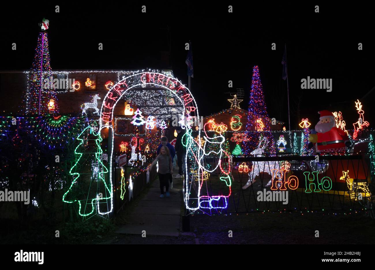 Loughborough, Leicestershire, Großbritannien. 16th. Dezember 2021. Kinder sehen extravagante Weihnachtsdekorationen und Lichter an einem Haus in der Nanpantan-Gegend von Loughborough aus. Credit Darren Staples/Alamy Live News. Stockfoto