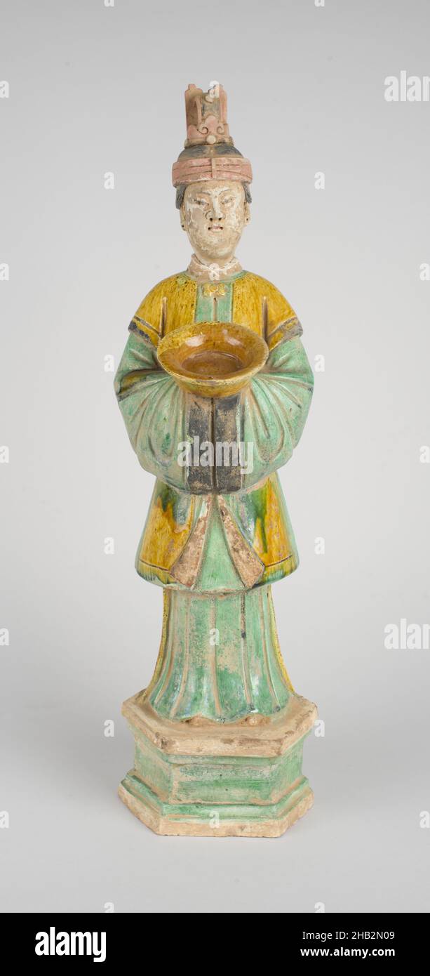 Stehende Figur einer Magd, die ein Gericht hält, Chinesisch, Ming-Dynastie, 1368–1644, Zhengde-Zeit, 1506–1521 oder Jiajing-Zeit, 1522–1566, Anfang bis Mitte des 16th. Jahrhunderts, Steingut mit bernsteinfarbenen und grünen Bleiglasuren, roten, weißen und schwarzen Pigmenten, hergestellt in China, Asien, Keramik, Skulptur, Höhe: 19 5/16 Zoll (49 cm Stockfoto