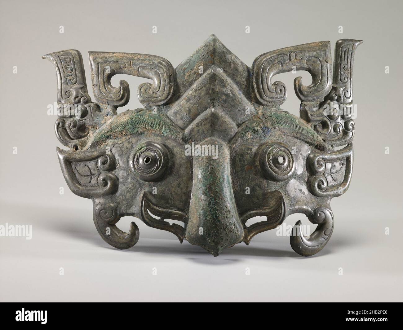 Applikation in Form einer Zoomorphen Maske, Chinesisch, westliche Zhou-Dynastie, 1050–771 v. Chr., 10th. Jahrhundert v. Chr., Bronze, Taiyuan, Provinz Shanxi, China, Asien, Metallbearbeitung, Höhe entlang der zentralen vertikalen Achse: 10 15/16 Zoll (27,8 cm Stockfoto