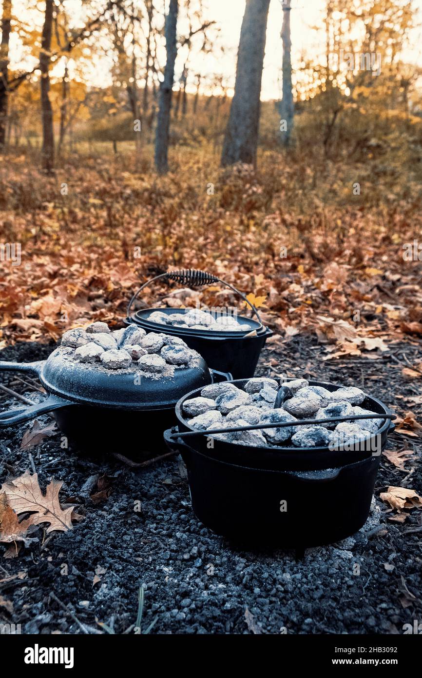 Gusseiserne holländische Öfen mit heißen Kohlen auf der Oberseite. Stockfoto