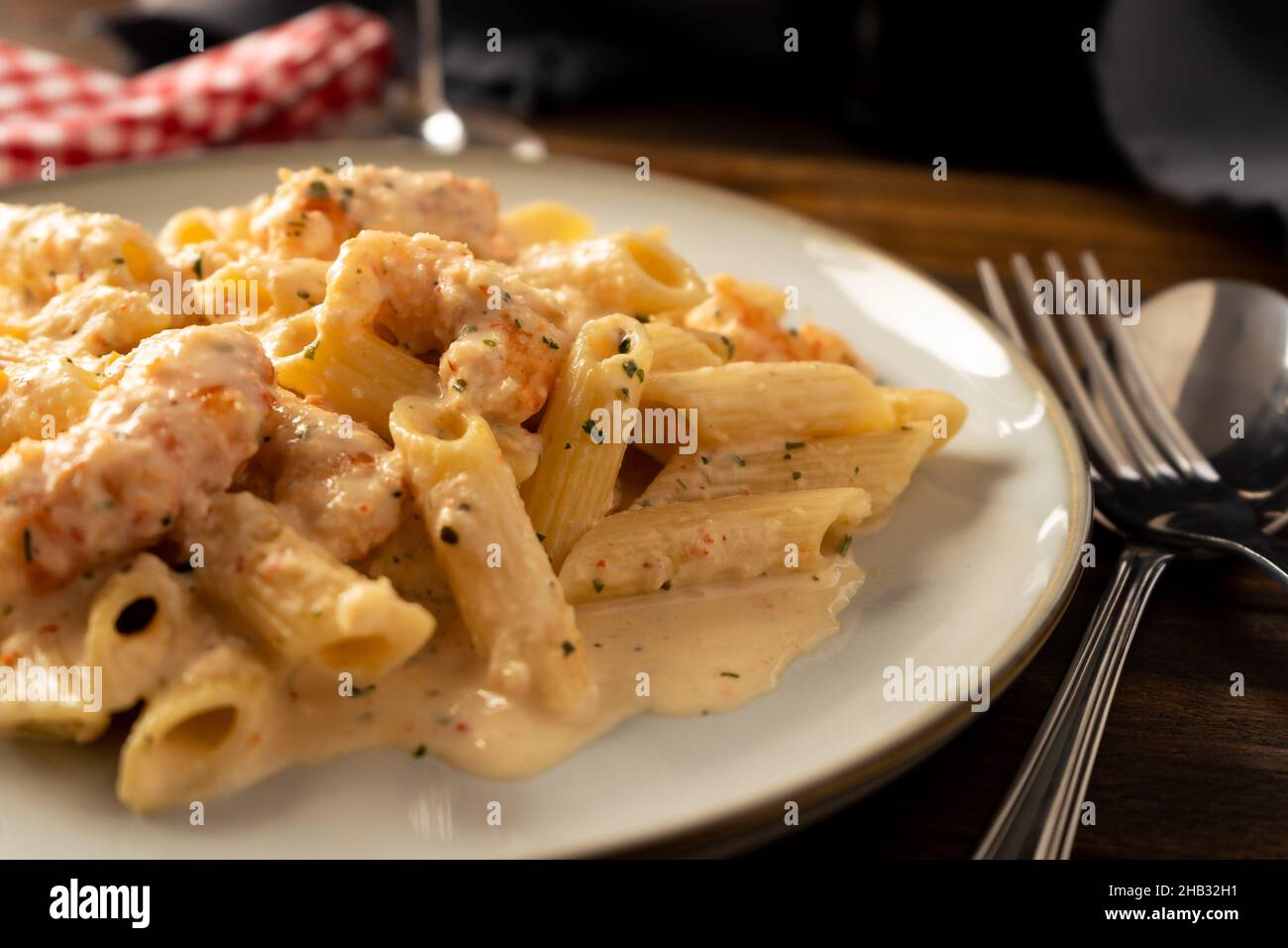 Eine Nahaufnahme einer trockenen Penne Rigate Pasta mit einer köstlichen Garnelen und Garnelencreme. Stockfoto