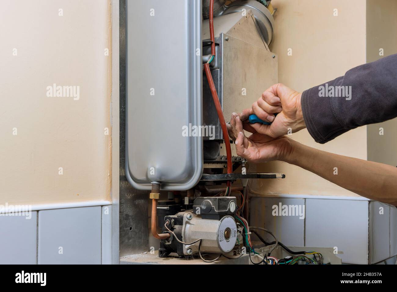Reparaturdienst, der einen Gaserhitzer mit Reparaturservice repariert Stockfoto