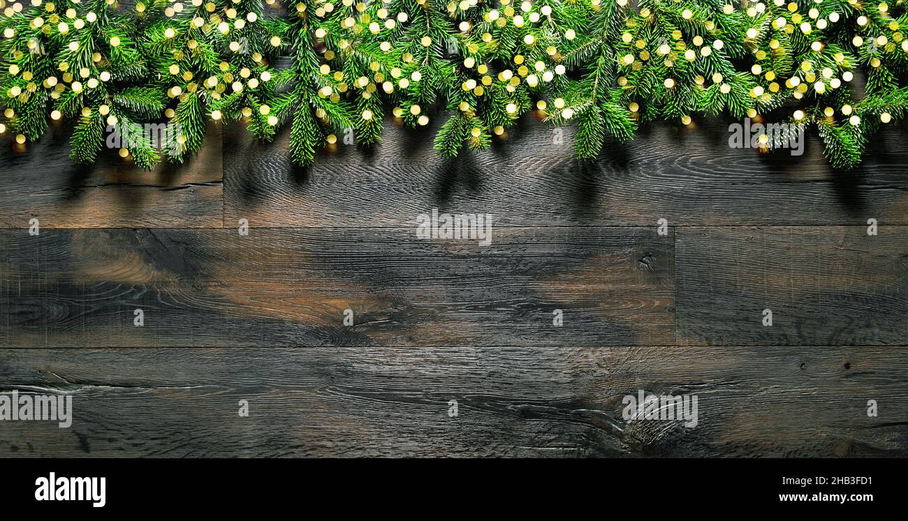 Weihnachtlicher Hintergrund mit goldenen Lichtern und Kiefernästen Stockfoto