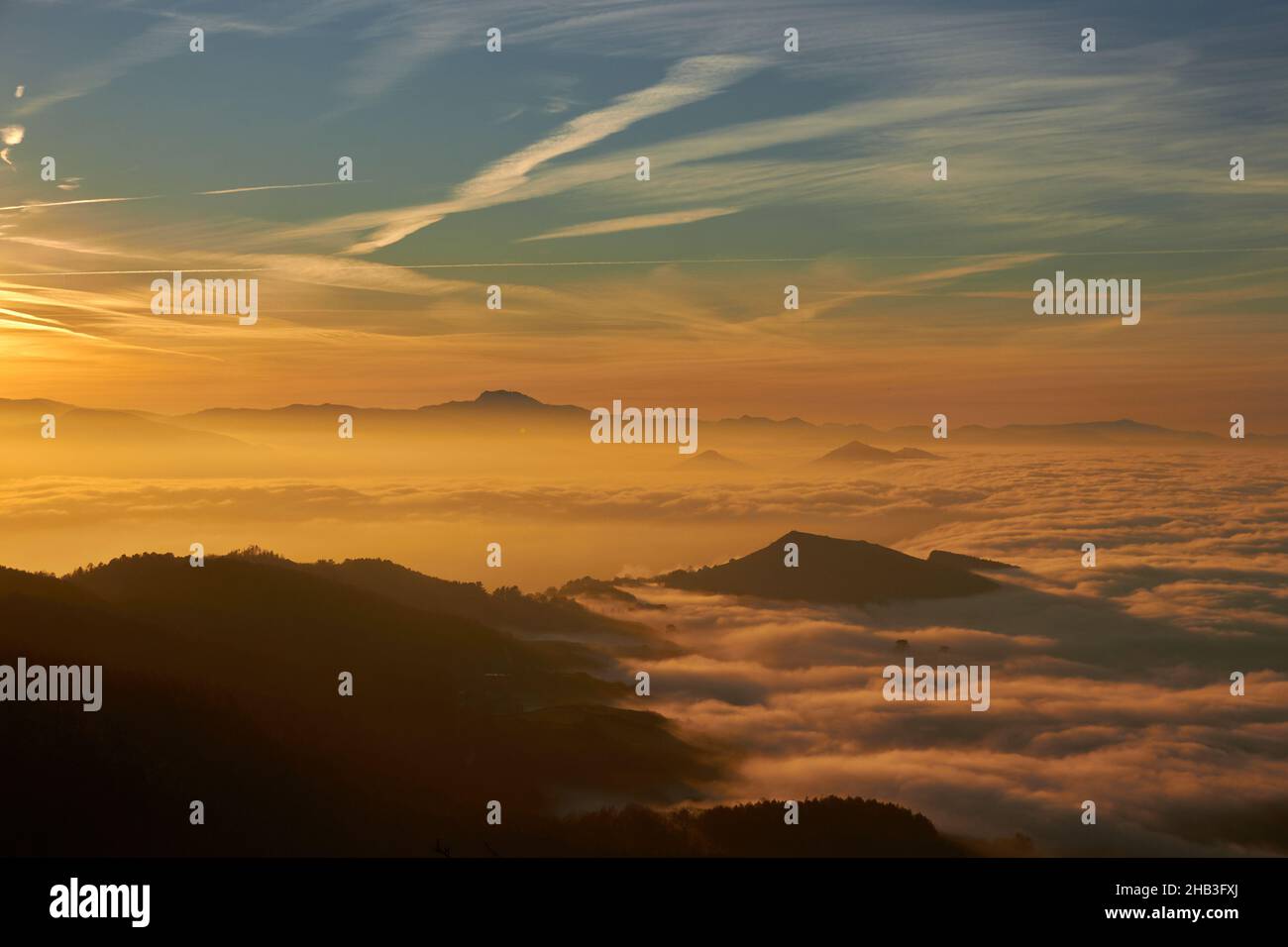 Landschaft eines Sonnenuntergangs über dem Meer, viele Wolken und orange Farben sind zu sehen Stockfoto