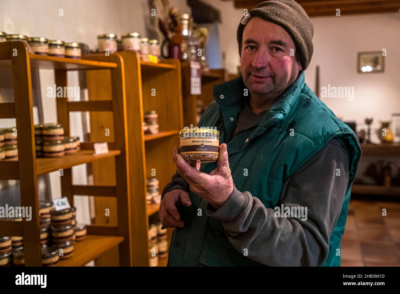 Einer der beiden Besitzer von GAEC de Bérengou, Marc Tardieu, hält ein Glas hausgemachter Entenrillettes im Hofladen in Mézerville, Département Aude, Frankreich. Der familiengeführte Hof, vor mehr als 30 Jahren von Ginette und Jean-Baptiste gegründet und heute von Marc und Joël Tardieu geleitet, hält seine Enten im Freien in den Hügeln der Region La Piège, verarbeitet sie vor Ort zu Confit, Foie gras und Terrinen und verkauft sie in seinem eigenen Laden. Stockfoto