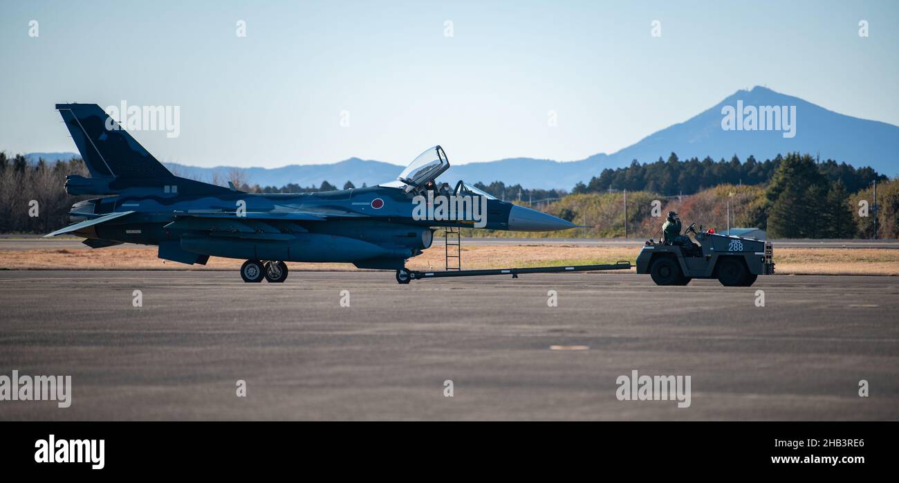 Mitarbeiter der japanischen Selbstverteidigungskräfte schleppen ein F-2A-Flugzeug, das 3rd Tactical Fighter Squadron, 7th Air Wing, auf der Hyakuri Air Base, Japan, am 13. Dezember 2021 zugewiesen wurde. US-Marineinfanteristen mit Marine Fighter Attack Squadron 112 arbeiten im Rahmen des Aviation Training Relocation-Programms mit Mitarbeitern der Japan Air Self-Defense Force auf dem Luftwaffenstützpunkt Hyakuri zusammen, um die US-japanische Allianz zu stärken. (USA Marine Corps Foto von CPL. Evan Jones) Stockfoto