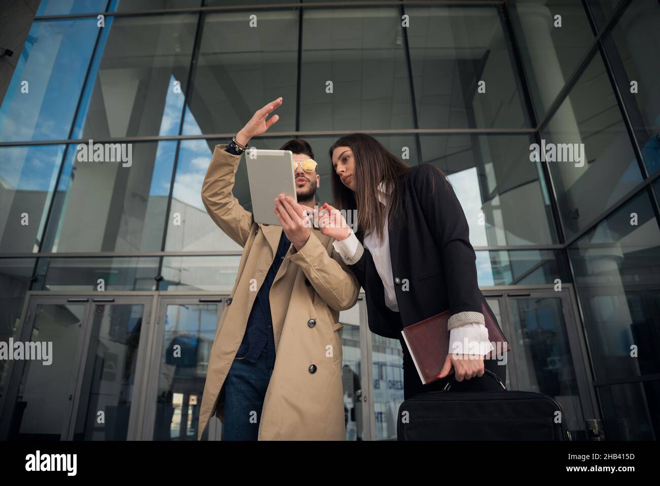 Männlicher Assistentist zeigt seinem Chef die Pläne auf dem Tablet Stockfoto