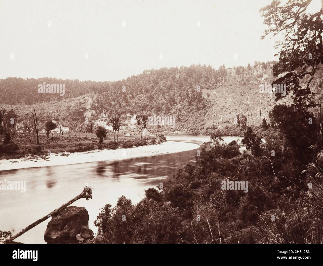 Buller Gorge bei White Cliffs, Burton Brothers Studio, um 1895, Buller, Schwarzweiß-Fotografie, Biegung in einem breiten Fluss mit niedrigen Hügeln im Hintergrund, teilweise von Busch gereinigt. Der Fluss kurvig nach oben links und es gibt 2 Häuser in der Ferne auf dem gegenüberliegenden Ufer. Bush nimmt den rechten Vordergrund ein, mit einem großen Baum, der den größten Teil der Höhe des Rahmens ganz rechts ausdehnt. Ein umgedrehten Baumstamm liegt schräg von einem Felsen im Fluss in das Wasser unten links Stockfoto