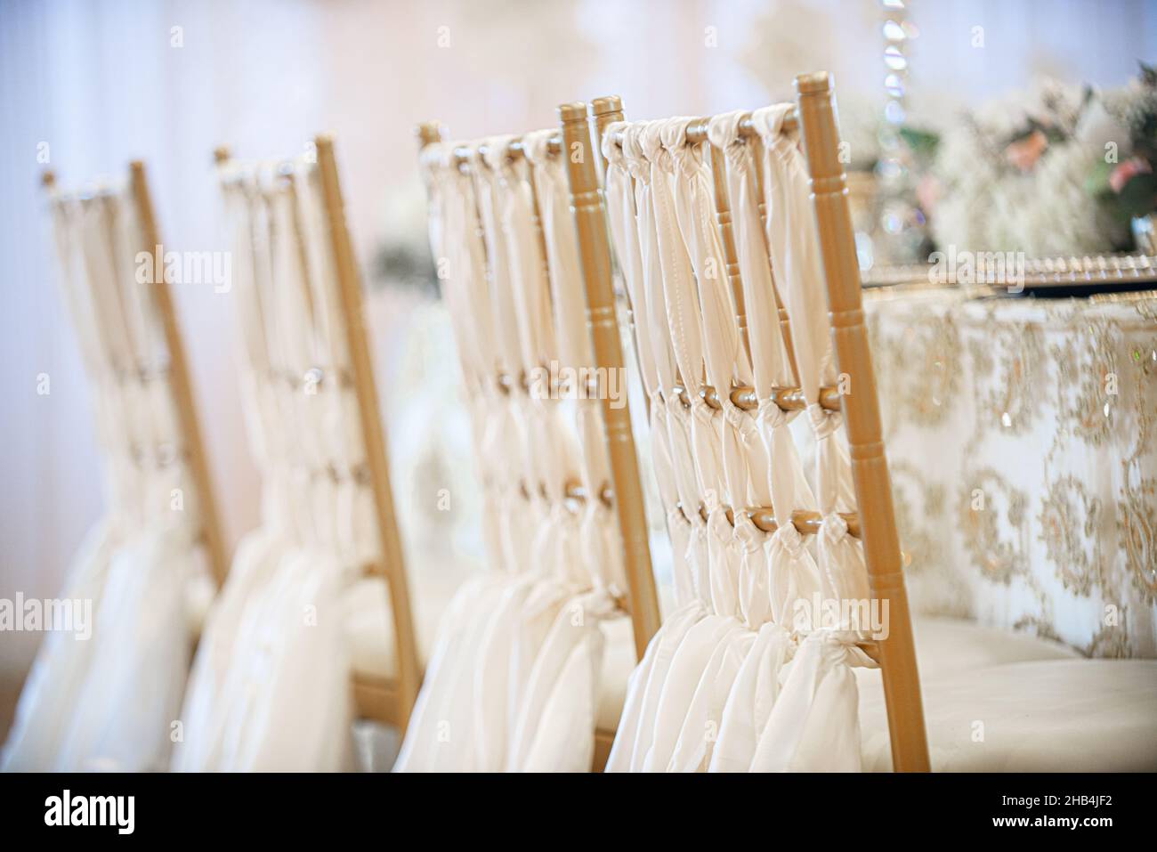 Elegante goldene chiavari-Stühle mit weißen Leinentüchern und Hochzeitsessen Stockfoto