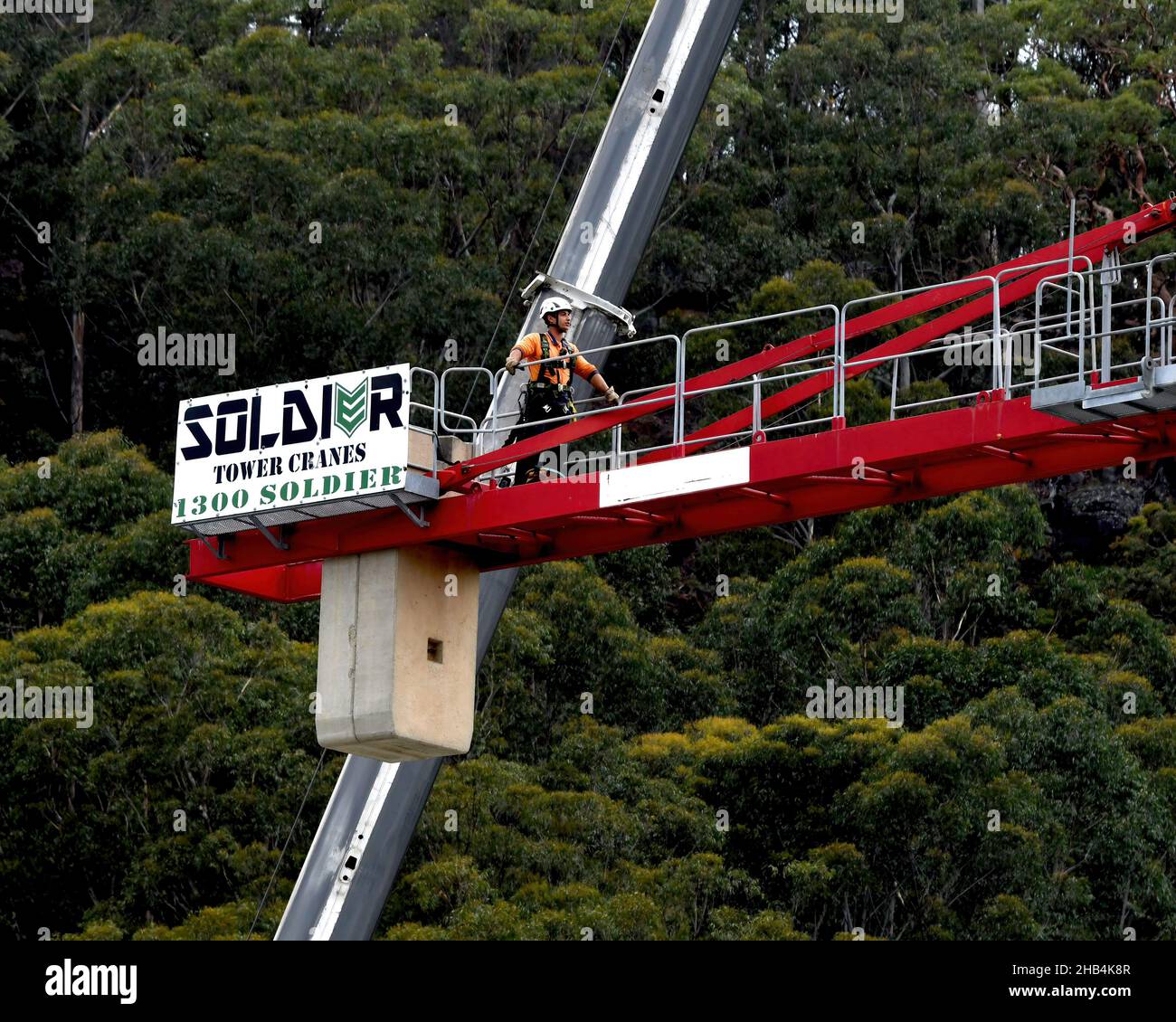 8:10 Uhr 7. Dezember 2021: Gosford, NSW, Australien. Arbeiter demontieren den Turmdrehkran vor Ort (Entfernen der Gegengewichte) auf dem fertig gestellten sozialen Netzwerk Stockfoto