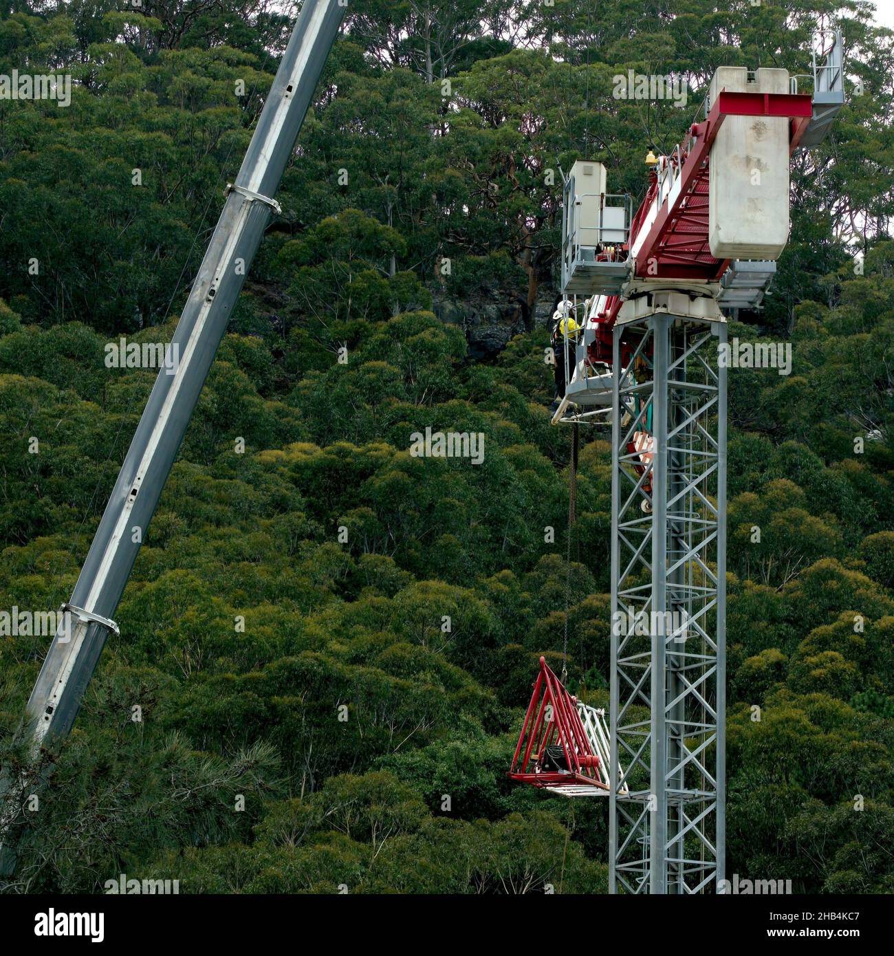 8:54 Uhr, 7. Dezember 2021: Gosford, NSW, Australien - Arbeiter demontieren den vor Ort arbeitenden Turmdrehkran (Download des Arbeitsschiebers) auf dem nun fertig gestellten Stockfoto