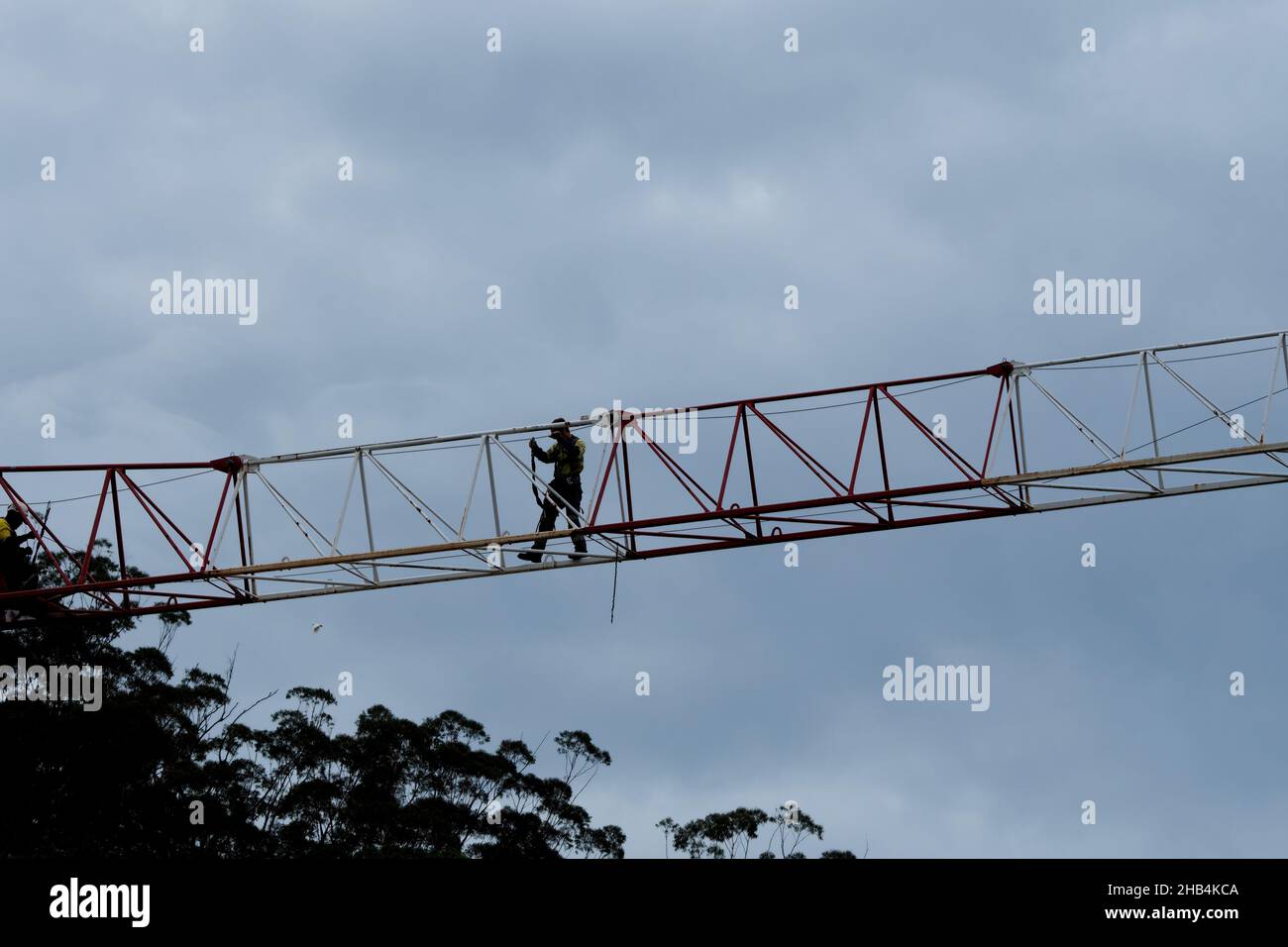 8:03:00 Uhr, 7. Dezember 2021: Gosford, NSW, Australien - Arbeiter demontieren den vor Ort arbeitenden Turmdrehkran (Abklemmen des Arbeitsschiebers) auf dem nun fertig Stockfoto