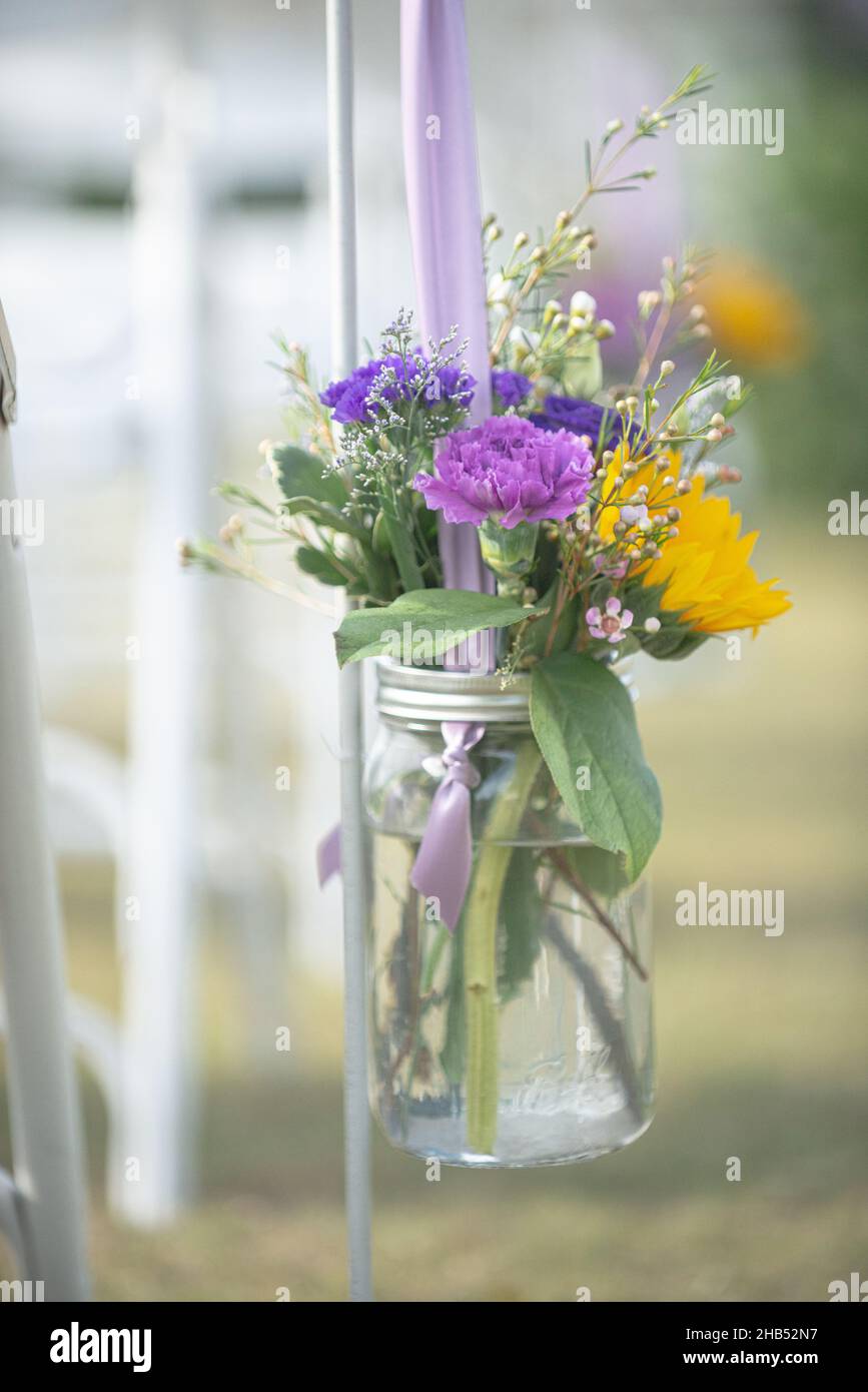 Sonnenblumen- und Pupelrosen im Einmachglas florales Dekor auf der Hochzeitsinsel Stockfoto