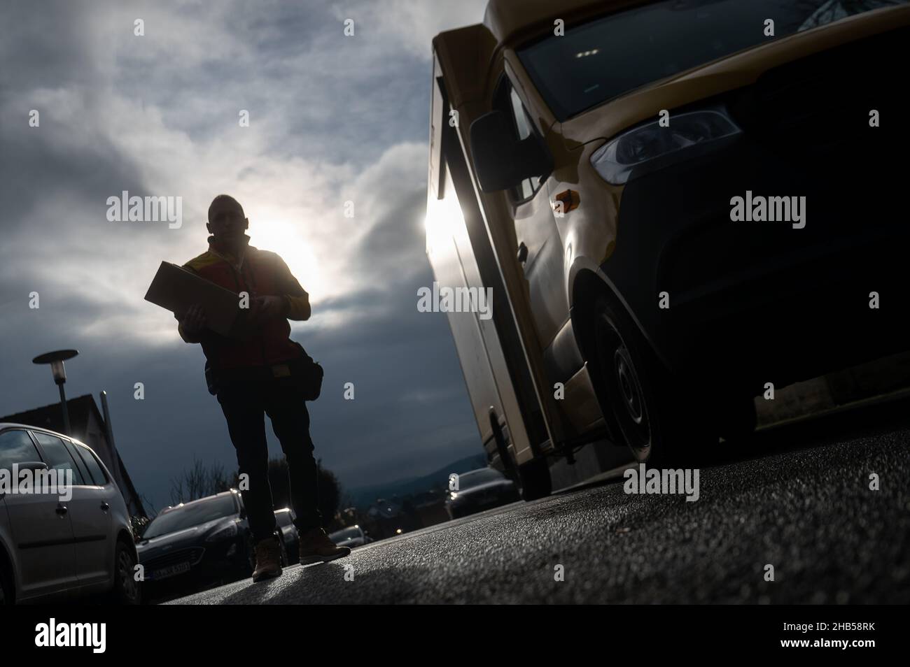 Ober Ramstadt, Deutschland. 15th Dez 2021. Ein DHL-Mitarbeiter liefert ein Paket aus. Quelle: Sebastian Gollnow/dpa/Alamy Live News Stockfoto