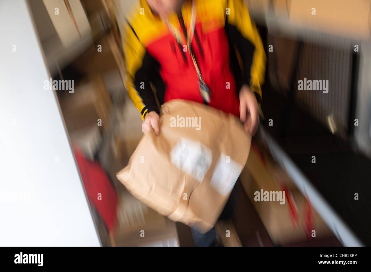 Ober Ramstadt, Deutschland. 15th Dez 2021. Ein DHL-Mitarbeiter nimmt ein Paket aus seinem Transporter. (Wischeffekt aufgrund langer Exposition) Kredit: Sebastian Gollnow/dpa/Alamy Live News Stockfoto
