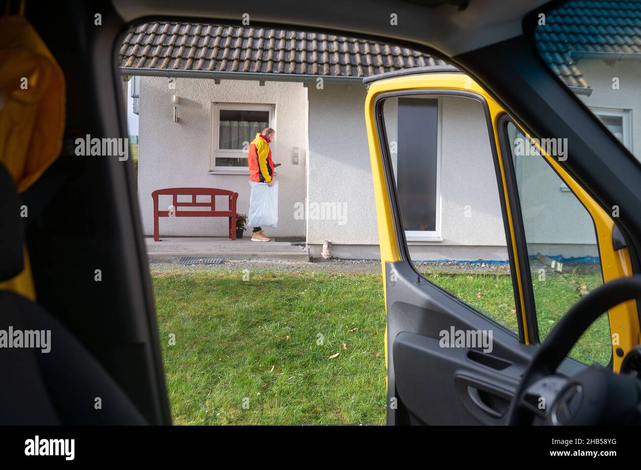Ober Ramstadt, Deutschland. 15th Dez 2021. Ein DHL-Mitarbeiter liefert ein Paket aus. Quelle: Sebastian Gollnow/dpa/Alamy Live News Stockfoto