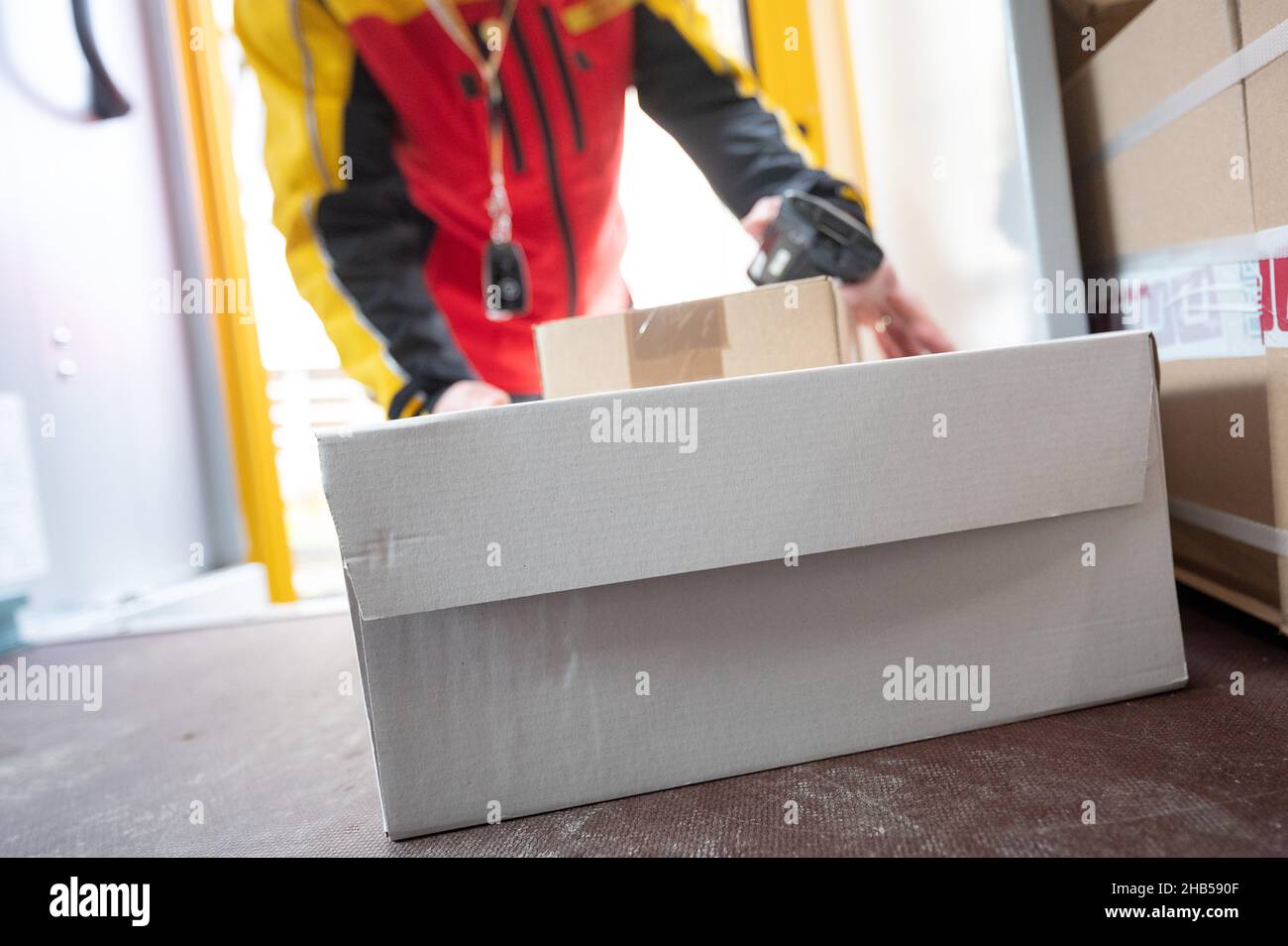 Ober Ramstadt, Deutschland. 15th Dez 2021. Ein DHL-Mitarbeiter nimmt ein Paket aus seinem Van. Quelle: Sebastian Gollnow/dpa/Alamy Live News Stockfoto