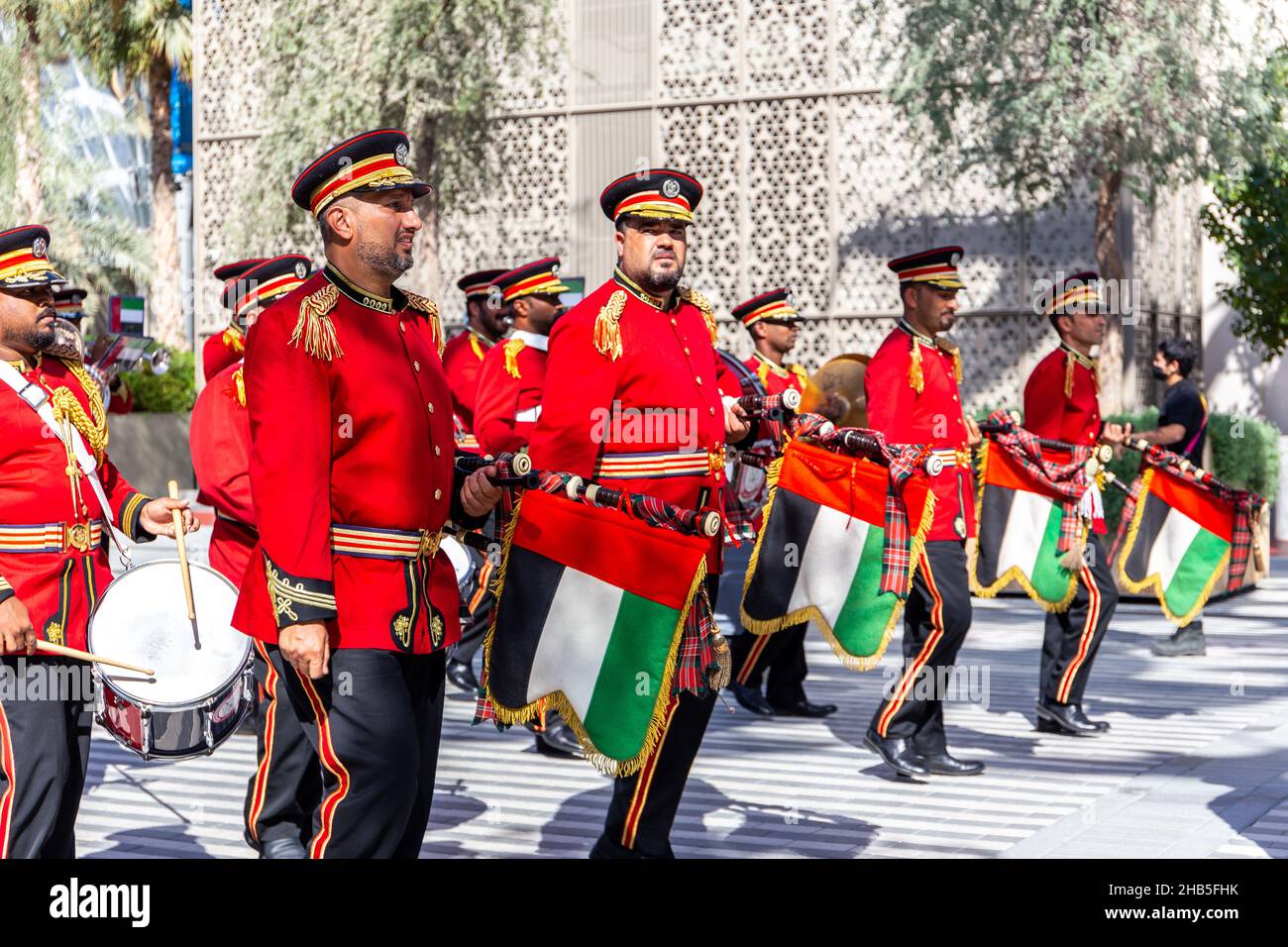 Dubai, VAE, 09.12.2021. Das Brass-Orchester der Emirati Police tritt bei der Expo 2020 Dubai Daily Parade auf, Männer in roten Suiten tragen die uae nationa Stockfoto